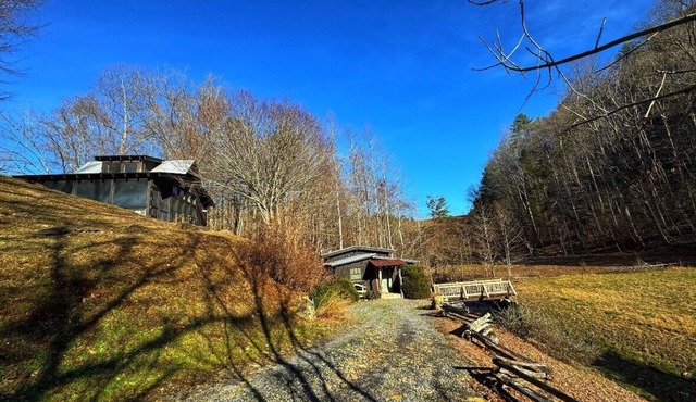 These charming cabins blend modern design with rustic beauty, offering a peaceful retreat where the main cabin sits one step from a stream, perfect for dining by the water, with stunning views of the surrounding landscape.